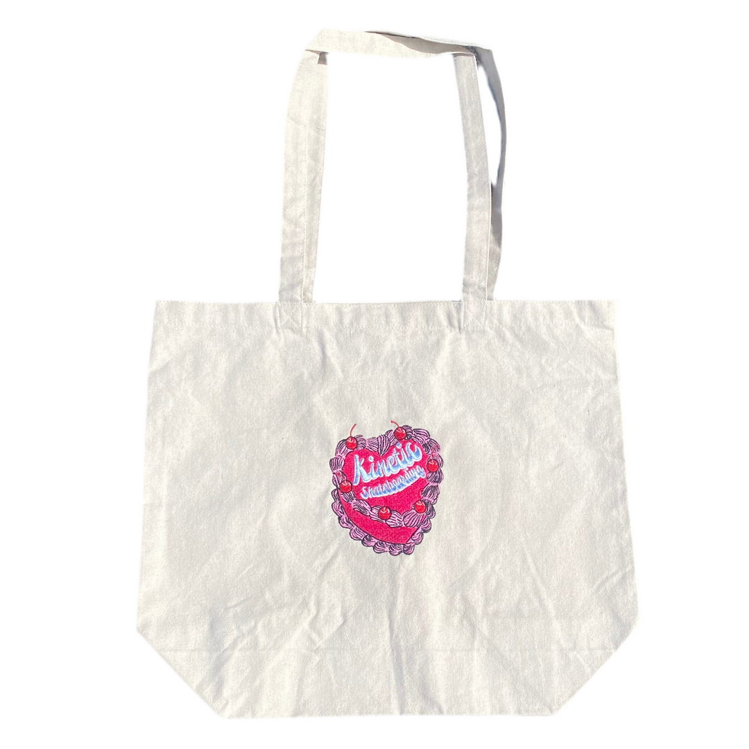 White tote bag with a pink and red heart design on a white background