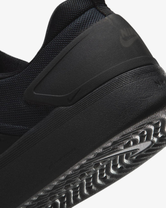 Close-up of a black sneaker with textured sole on a white background