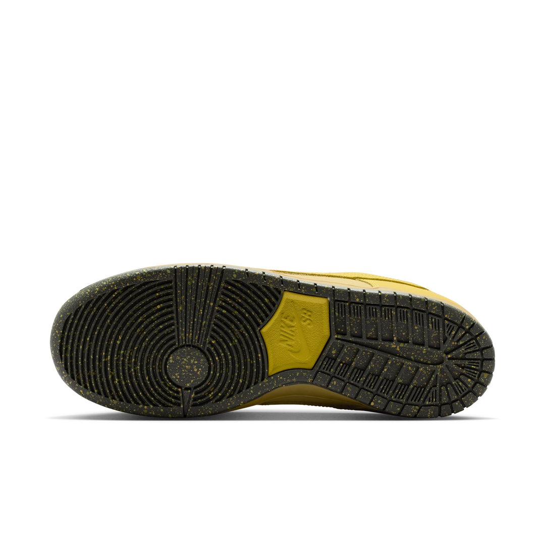 The outsole of a Nike sneaker, showing a black treaded rubber bottom with a yellow heel accent and a textured yellow Nike logo embossed on the side.