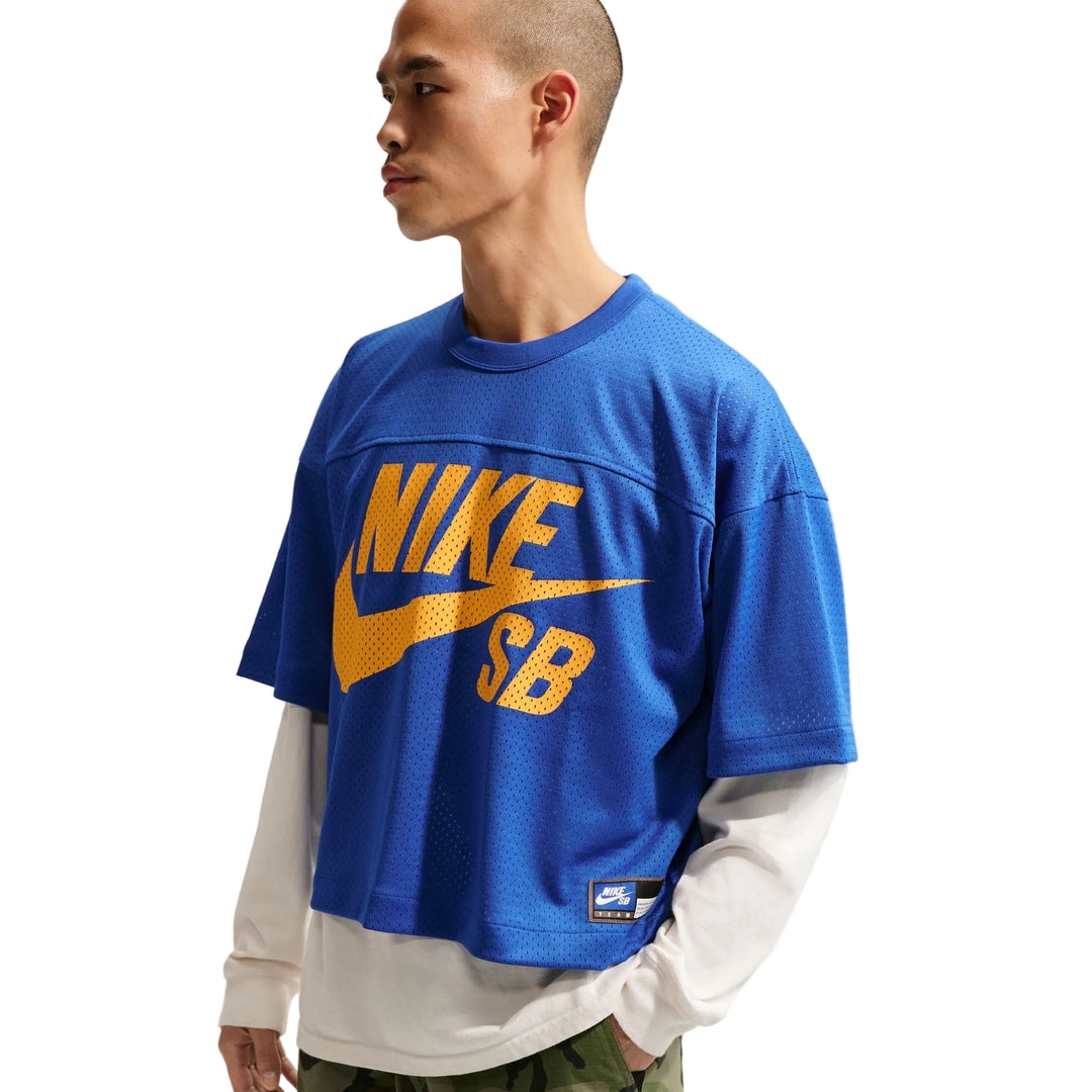 Person wearing a blue Nike SB shirt with yellow text on a white background