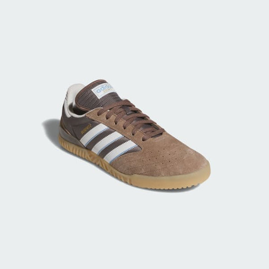 Brown Adidas sneaker with white stripes on a light gray background