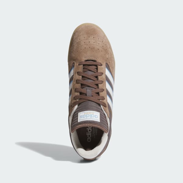 Brown Adidas sneaker with white stripes on a light gray background