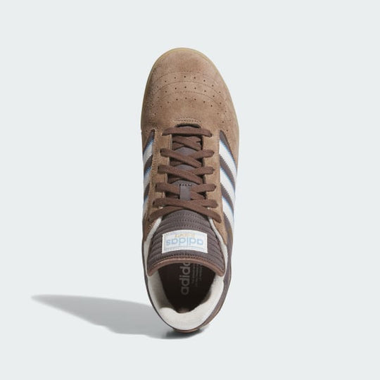 Brown Adidas sneaker with white stripes on a light gray background