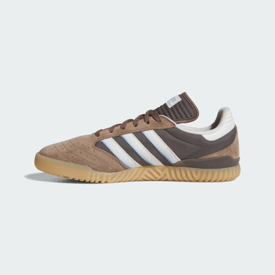 Brown and white sneaker with Adidas logo on a light gray background