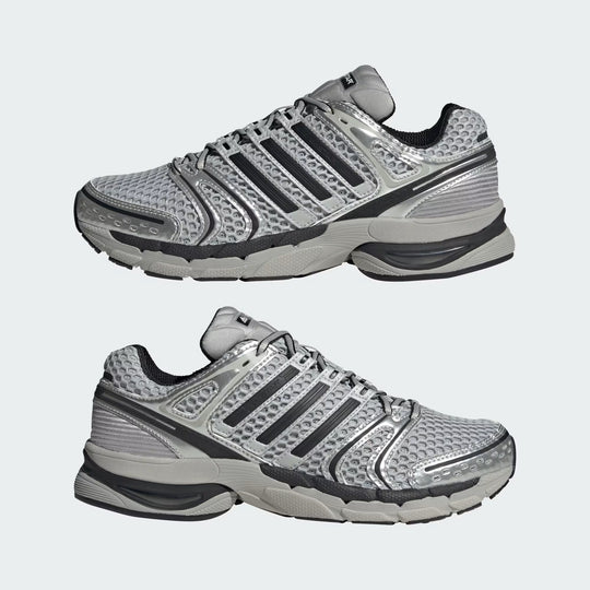 Pair of gray athletic shoes with black stripes on a light gray background