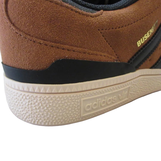 Brown Adidas shoe with visible branding on a light surface