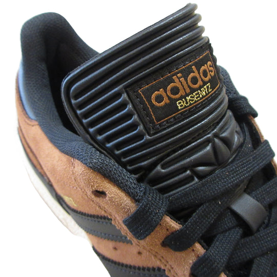 Close-up of a brown and black Adidas sneaker with visible branding.