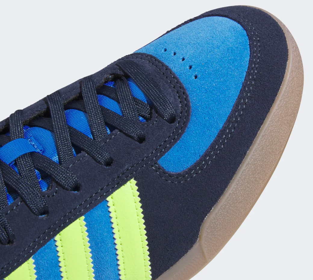 Navy and blue adidas sneaker with green stripes and navy laces