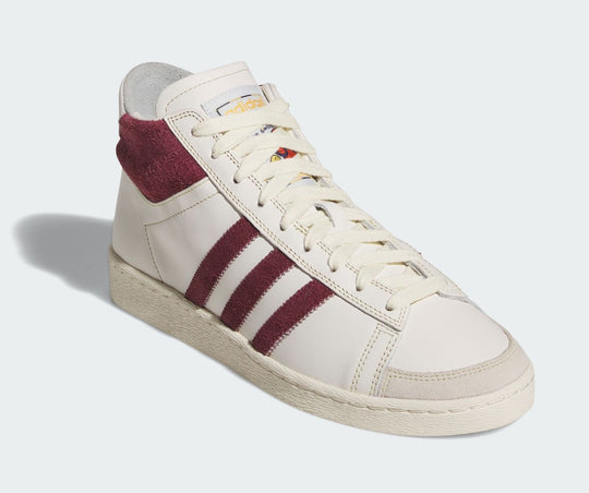 White sneaker with maroon stripes on a white background