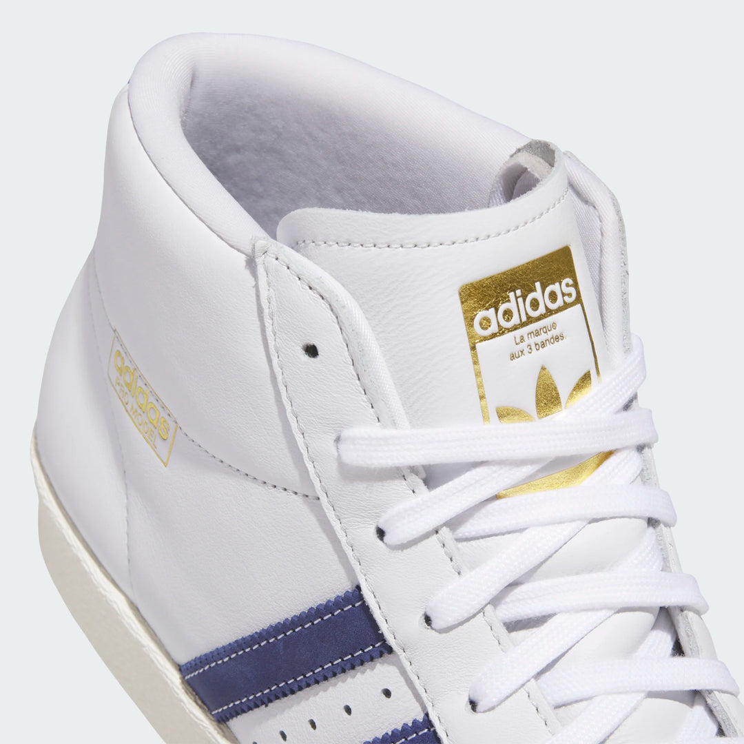 White Adidas sneaker with gold logo on a white background