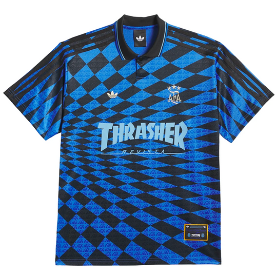 A short-sleeve Adidas x Thrasher collaboration polo shirt featuring a blue and black diamond pattern, with the Thrasher Revista logo on the chest and the Adidas logo on the collar.