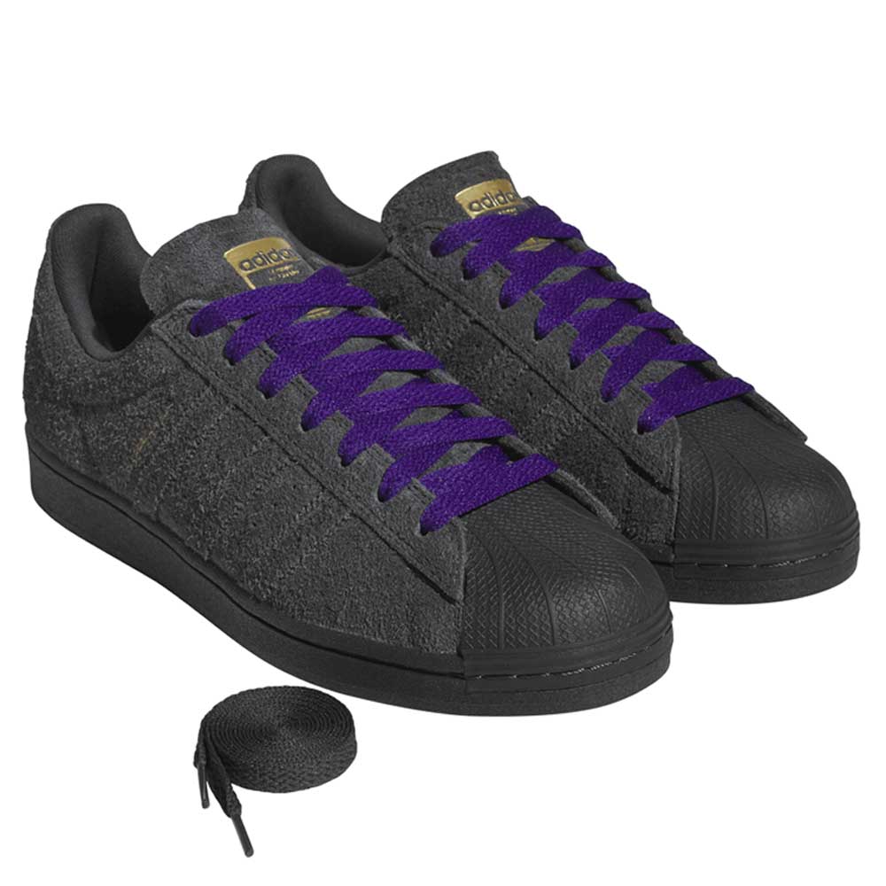 Gray sneakers with purple laces on a white background