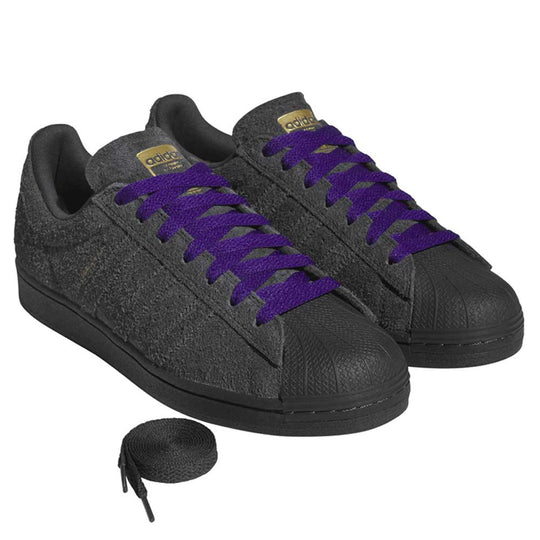 Gray sneakers with purple laces on a white background