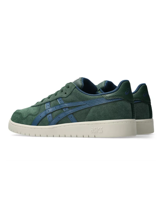 A pair of ASICS low-top sneakers in dark green suede with blue side stripes and a cream-colored midsole, shown against a plain white background.