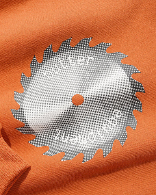 Circular saw blade with 'butler equipment' branding on an orange background