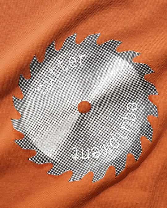 Saw blade with 'butter equipment' text on an orange fabric background