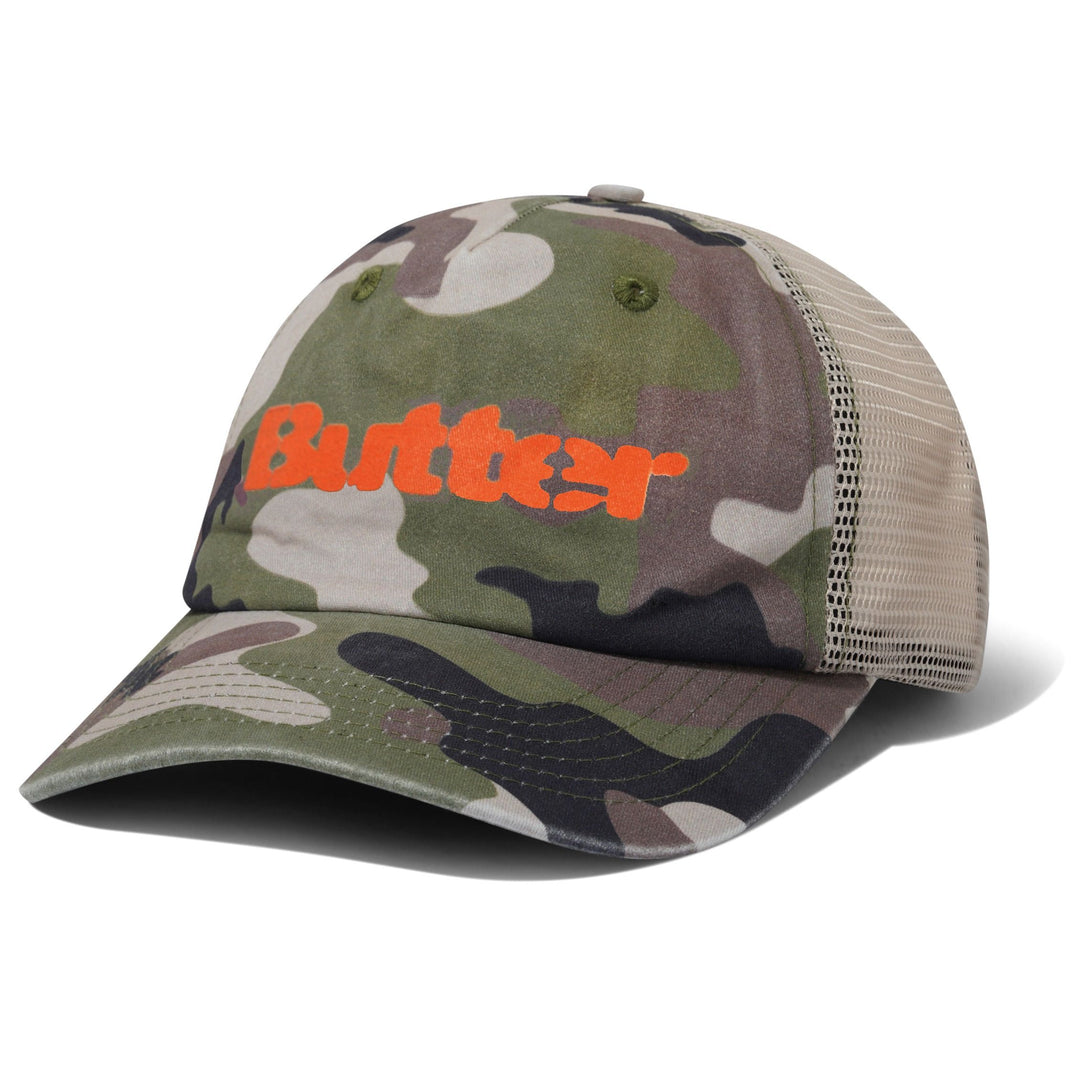 A camouflage trucker hat with a bright orange 'Butter' logo on the front, featuring a green and brown camo pattern on the front panel and brim, and beige mesh back panels, shown on a white background.