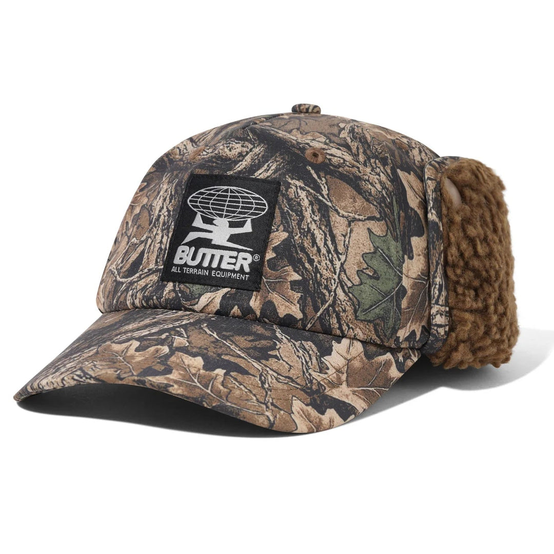 Camouflage baseball cap with earflaps and a butter brand logo 