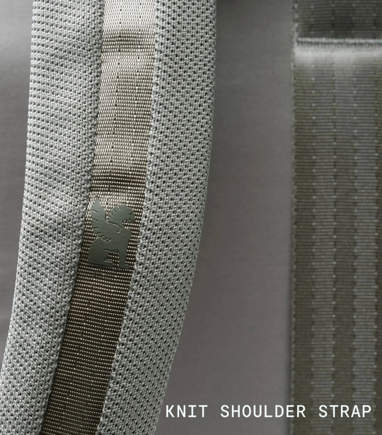 Close-up of a knit shoulder strap with visible texture and brand logo.