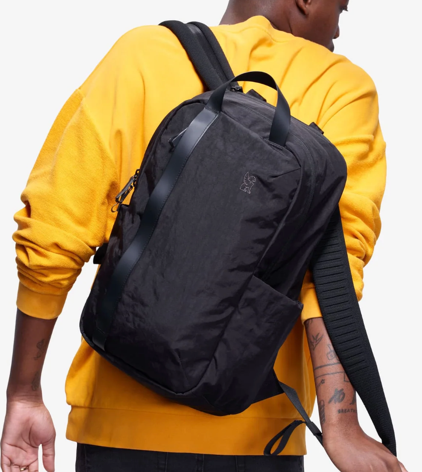 Person wearing a black backpack with a yellow sweatshirt
