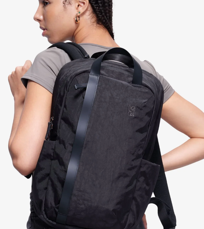 Person wearing a black backpack on a white background