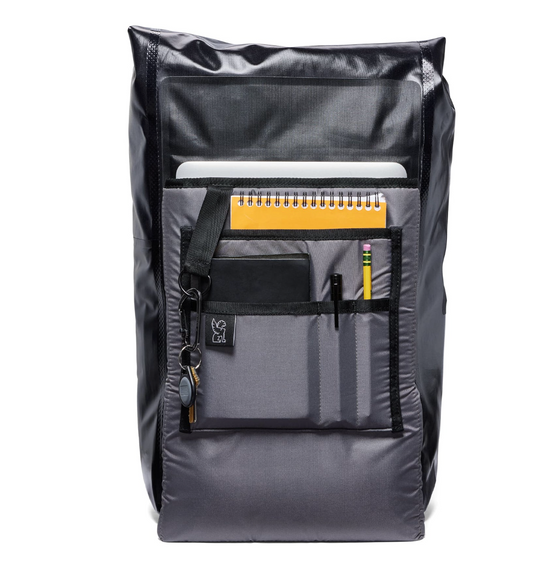 Gray backpack with multiple pockets and a notebook on a white background