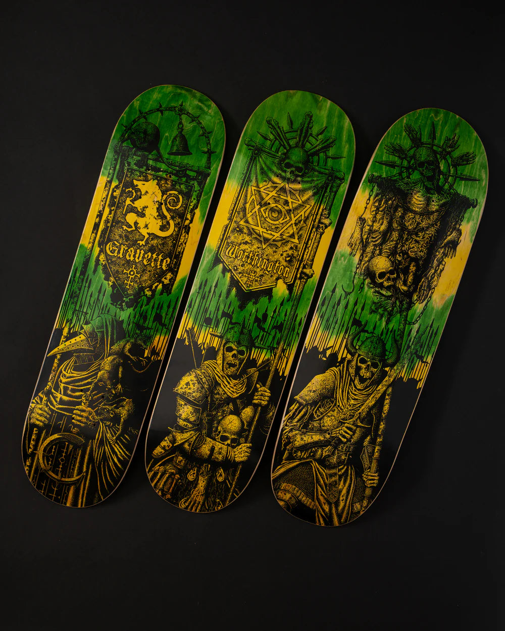 Three skateboard decks with green and yellow designs on a black background