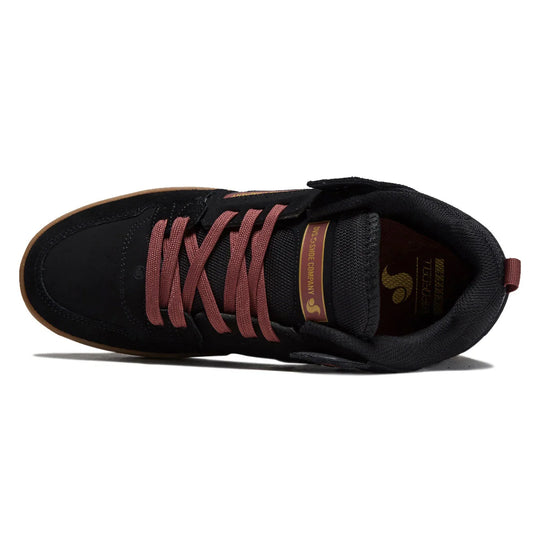 A black skate shoe with dusty rose laces, a brown gum sole, and gold branding on the side and tongue, shown from a top-down angle on a white background.