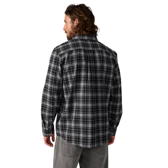 Man wearing a black and gray plaid shirt on a white background