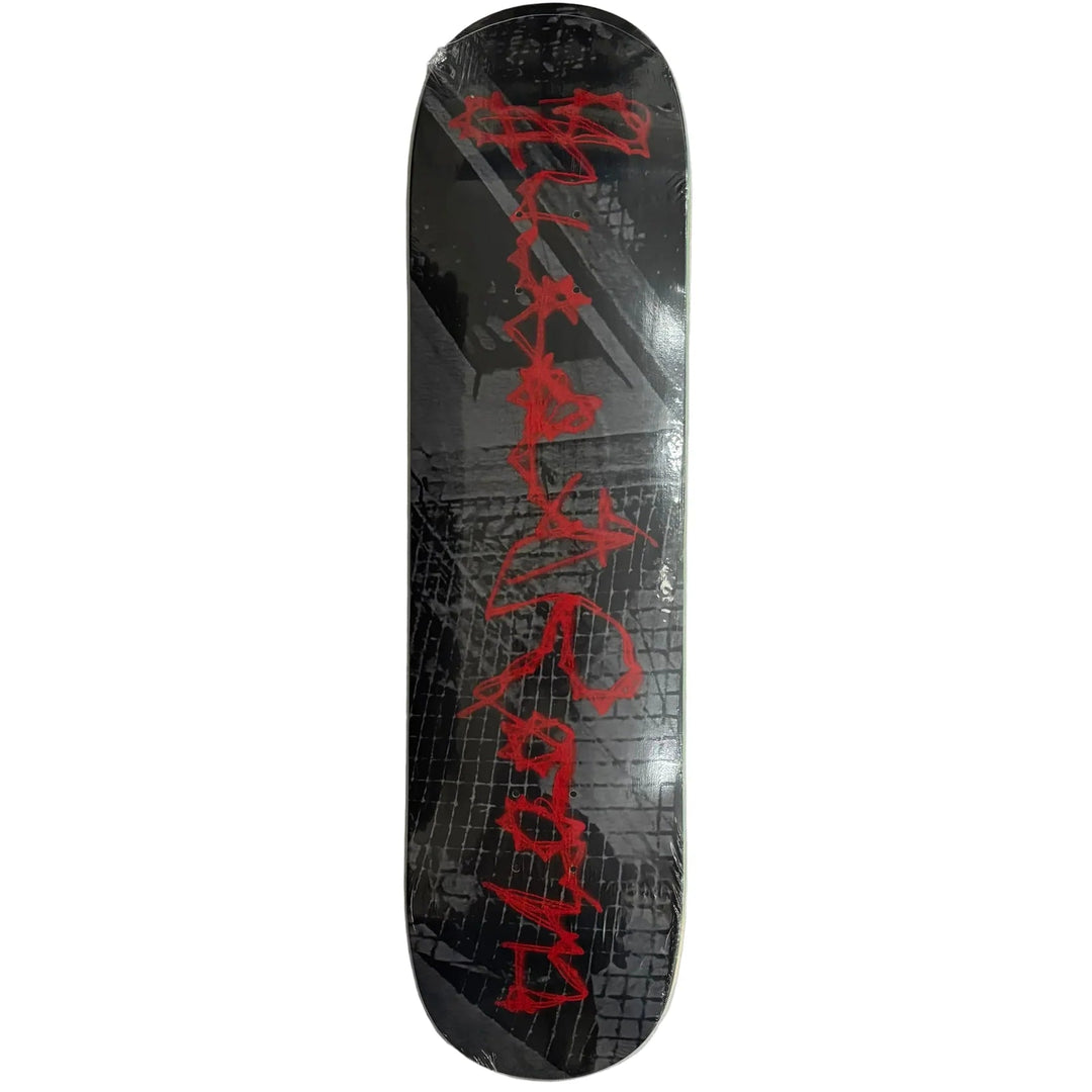 A skateboard deck with a black background, featuring a red gothic-style vertical logo and a gray grunge grid pattern, shown on a plain white background.