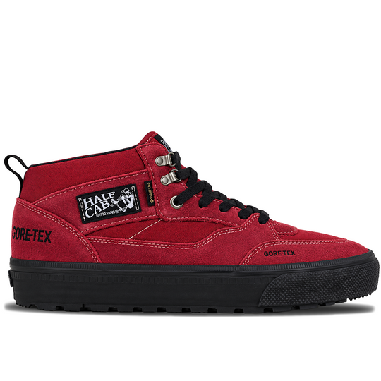 A red mid-top sneaker with a black sole, black laces, and a black and white &
