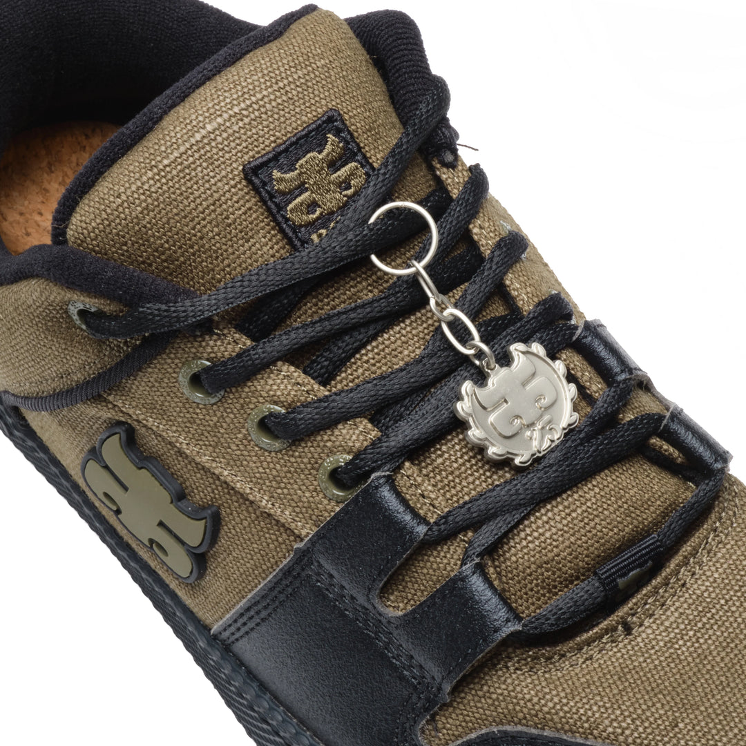 Brown sneaker with black laces and a ipath keychain 