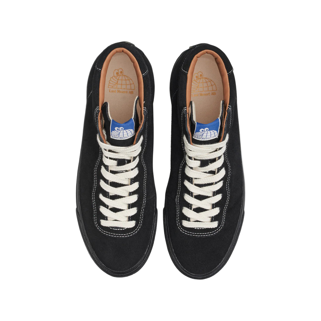 Pair of black sneakers with white laces on a white background