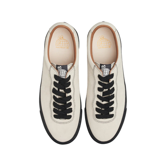 Pair of white sneakers with black laces on a white background