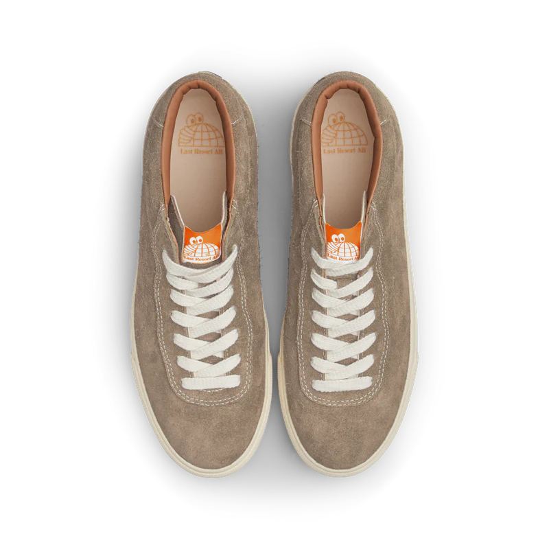 Pair of brown sneakers with white laces on a white background
