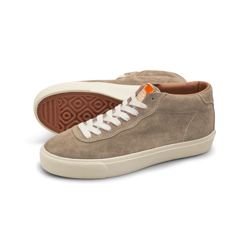 Pair of brown sneakers with white laces on a white background