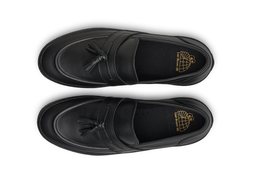 Black loafers with tassels on a white background
