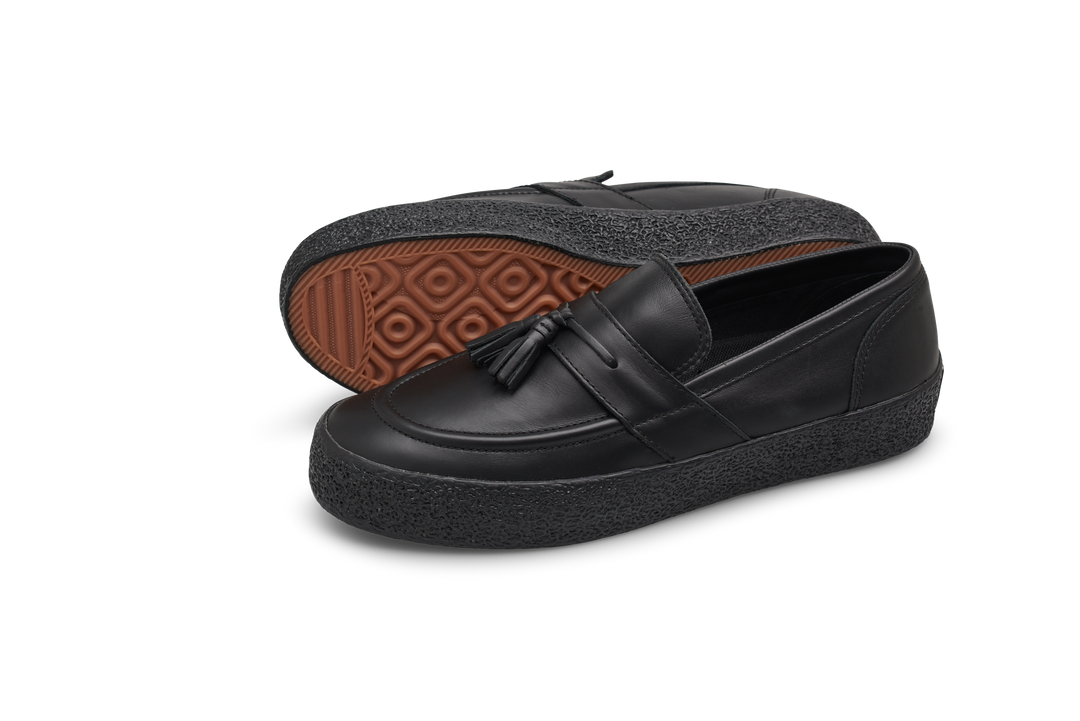 Black loafers with tassel on a white background