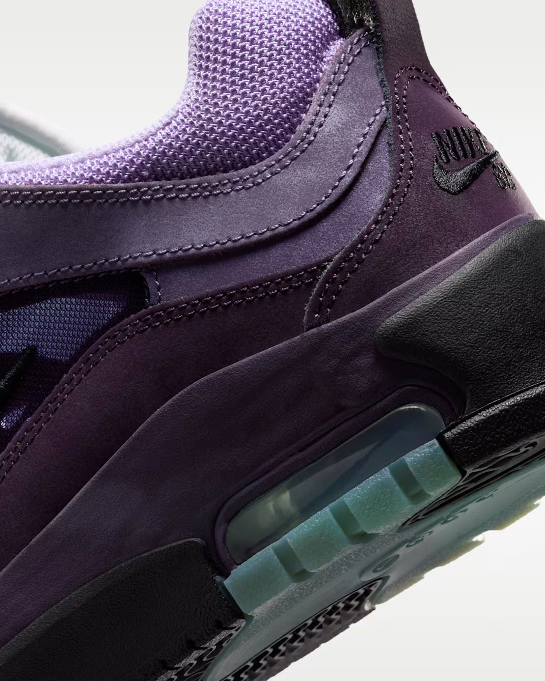 Close-up of a purple sneaker with a focus on the sole and nike 
brand logo.