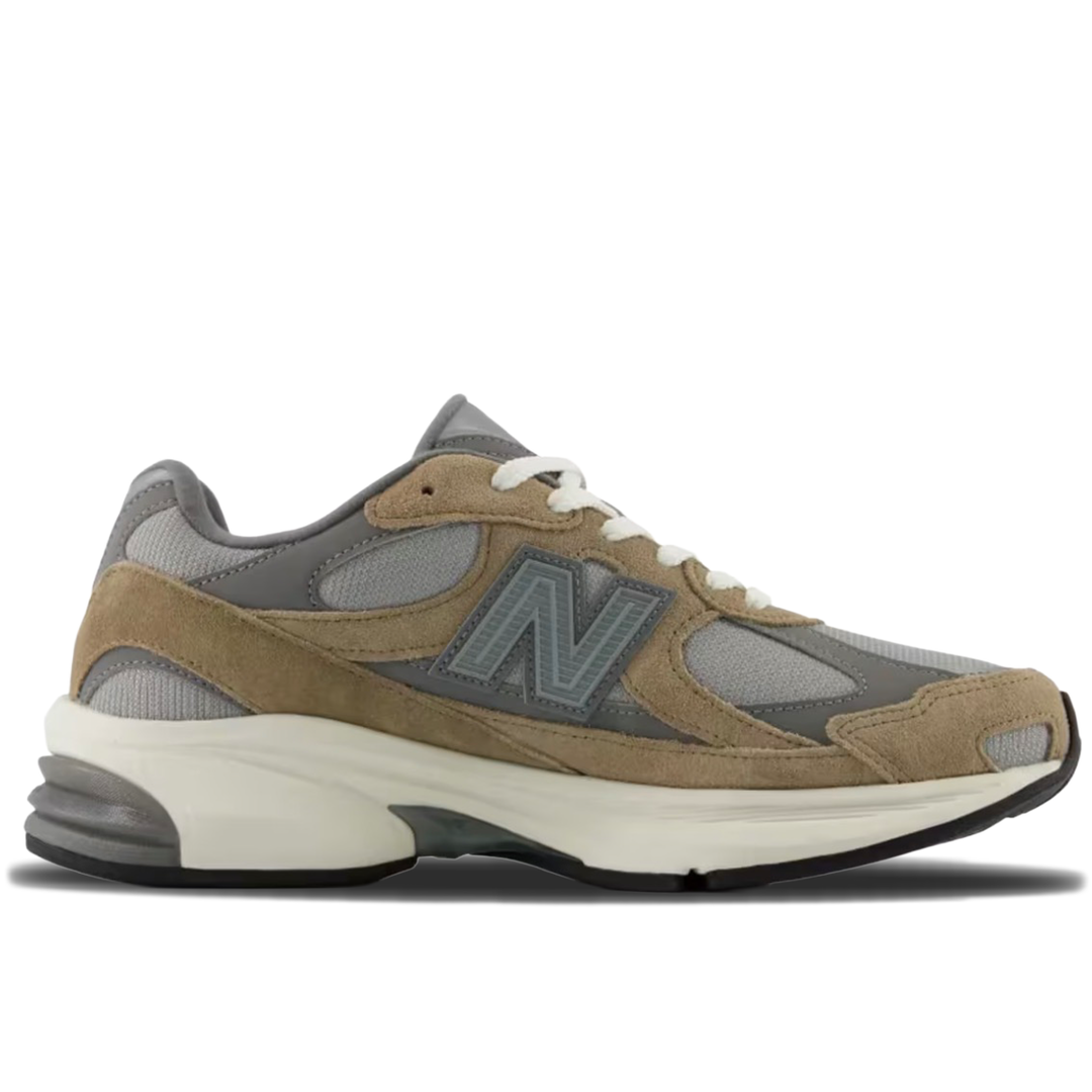 A New Balance sneaker in taupe suede and gray mesh with a chunky off-white midsole and white laces, shown from a side profile on a white background.