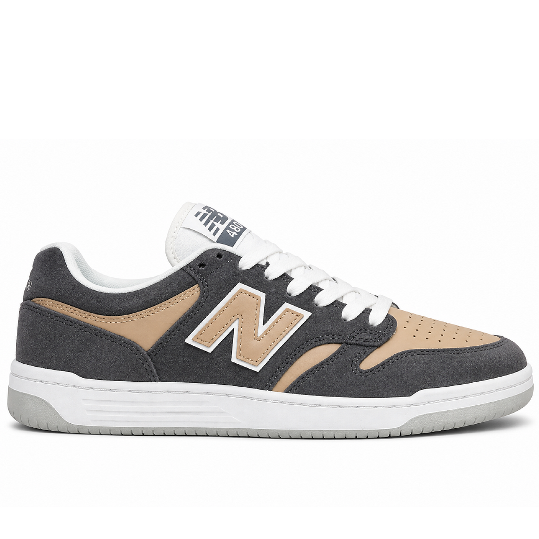 A New Balance sneaker in dark gray suede and tan leather with white laces and a white midsole, shown in a side profile on a white background.