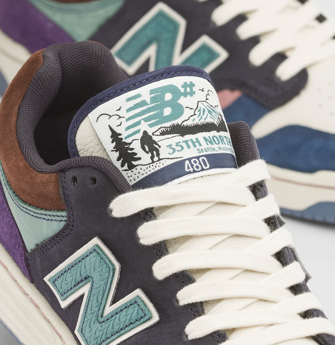 Close-up of a New Balance sneaker showing the tongue label with &