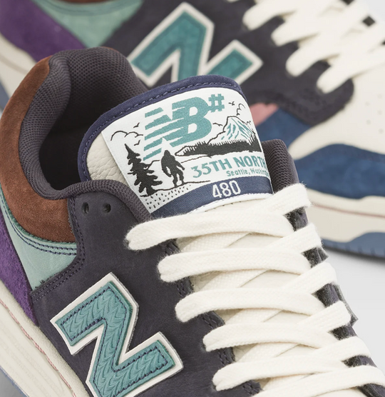 Close-up of a New Balance sneaker showing the tongue label with &