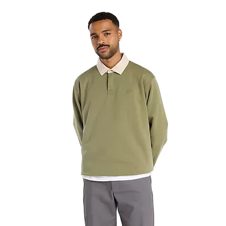 Man wearing a green sweater and gray pants on a white background