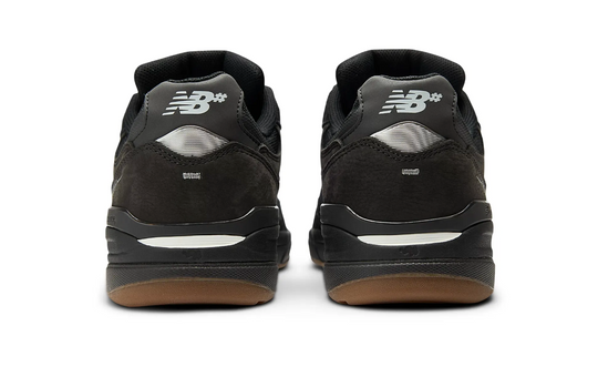 Black New Balance sneakers shown from the back on a white background
