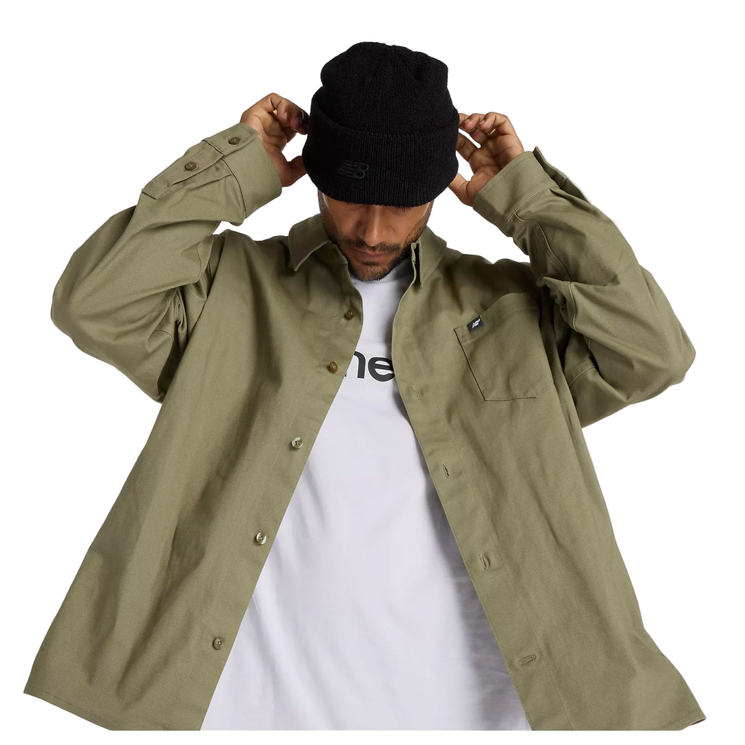 Person wearing a green jacket and black beanie on a white background