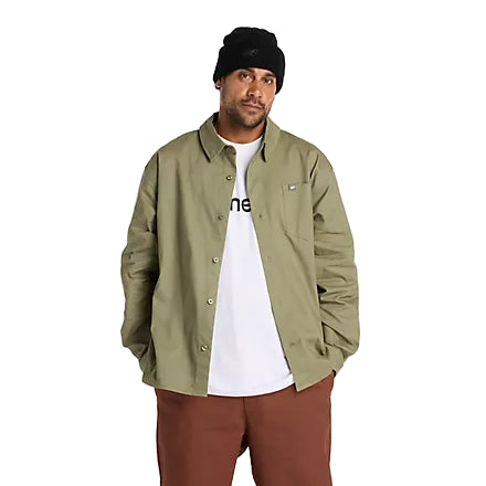 Man wearing a green jacket, white t-shirt, and brown pants on a white background