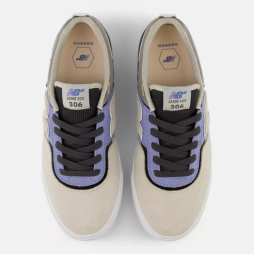 Pair of beige sneakers with purple accents on a white background