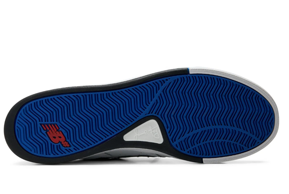 Close-up of a shoe sole with blue tread pattern and red logo on a white background