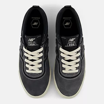 Black sneakers with white laces on a light gray background